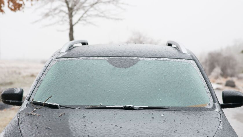 Ice-covered car windshield after a winter storm.