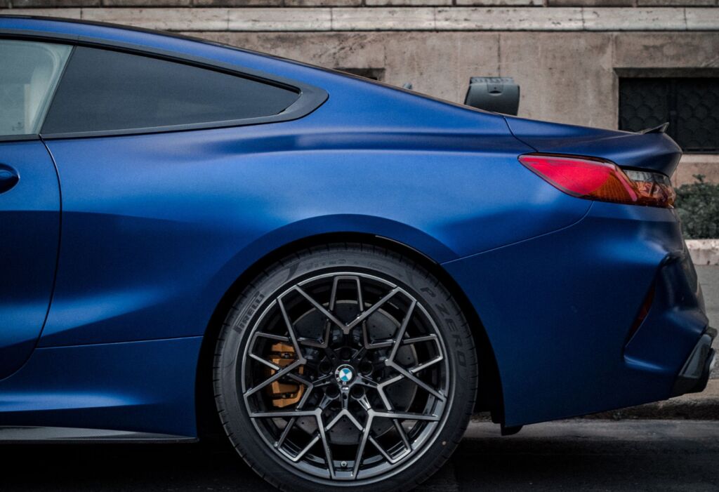 Blue sports coupe rear side with alloy wheel.