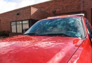 Red truck with hail dents and cracked windshield