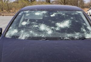 Car windshield with severe hail cracks and impact damage