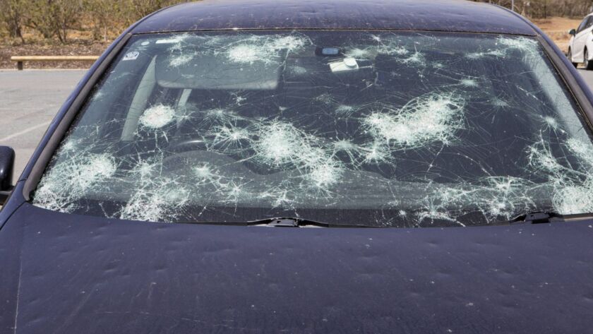 Car windshield with severe hail cracks and impact damage