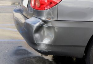 Gray car rear bumper with collision damage